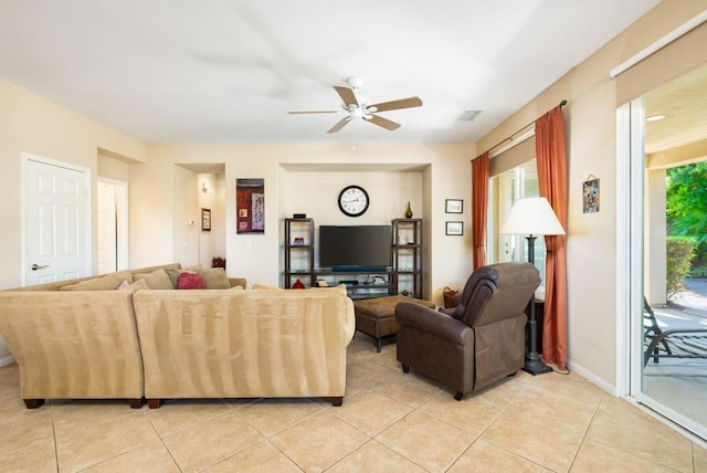 living room with ceiling fan, light tile patterned floors, and a healthy amount of sunlight