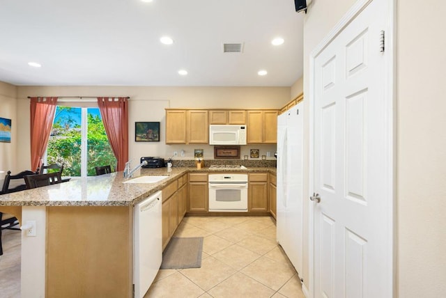 kitchen with light tile patterned floors, kitchen peninsula, white appliances, a breakfast bar, and sink