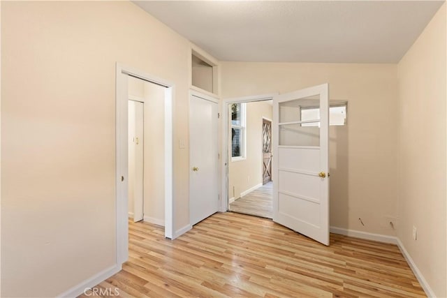 unfurnished room with light hardwood / wood-style floors and vaulted ceiling