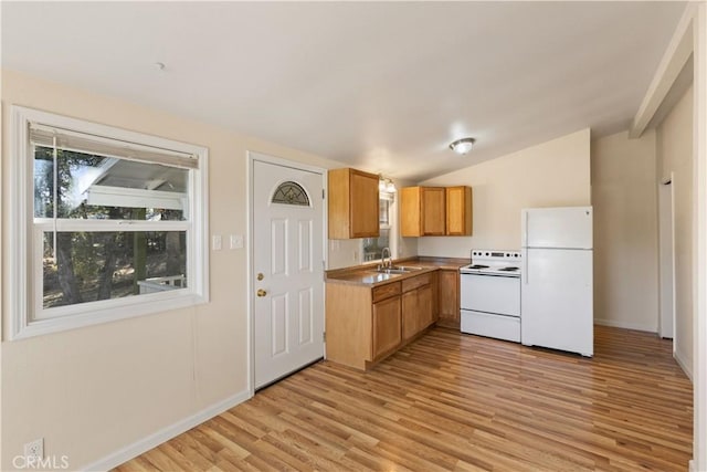 kitchen with lofted ceiling, white appliances, sink, and light hardwood / wood-style flooring