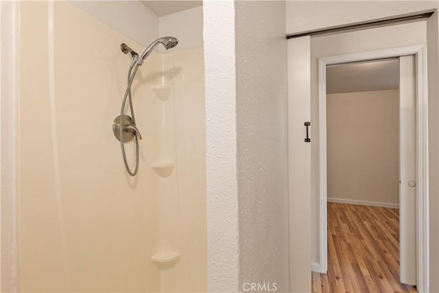 bathroom with a shower and hardwood / wood-style floors