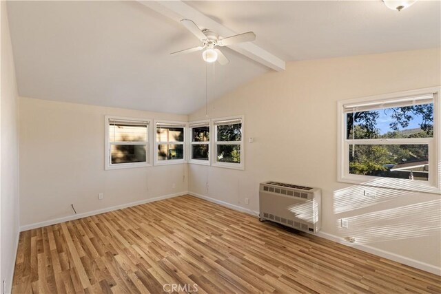 empty room featuring lofted ceiling with beams, light wood-type flooring, heating unit, and ceiling fan