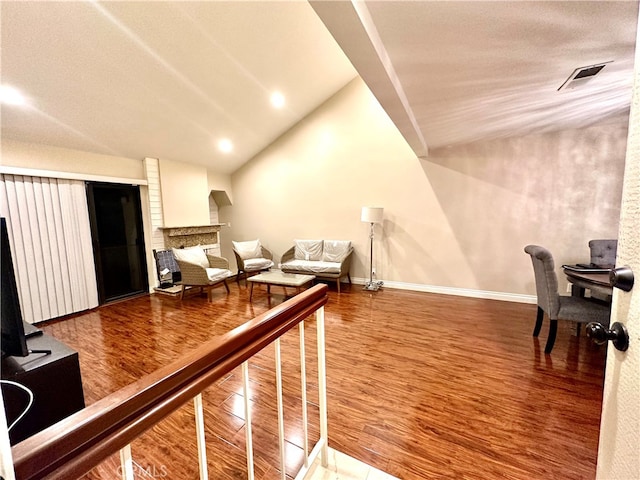 living room featuring lofted ceiling and hardwood / wood-style floors