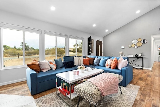 living room with light wood-type flooring and vaulted ceiling