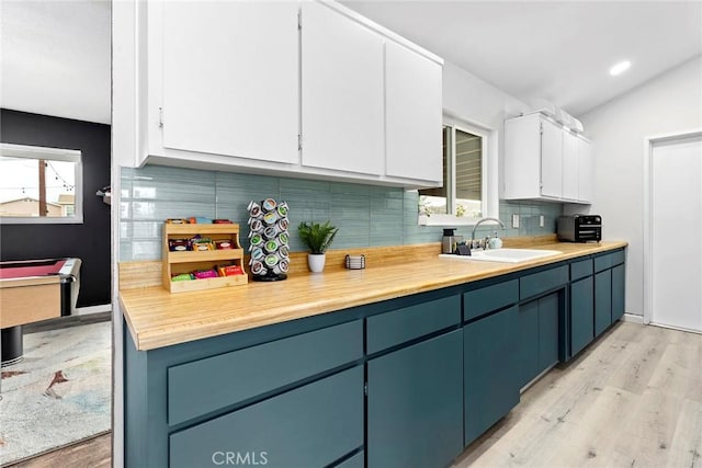 kitchen with sink, white cabinets, pool table, light wood-type flooring, and tasteful backsplash