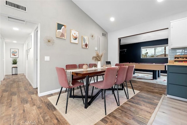 dining area with light wood-type flooring and lofted ceiling