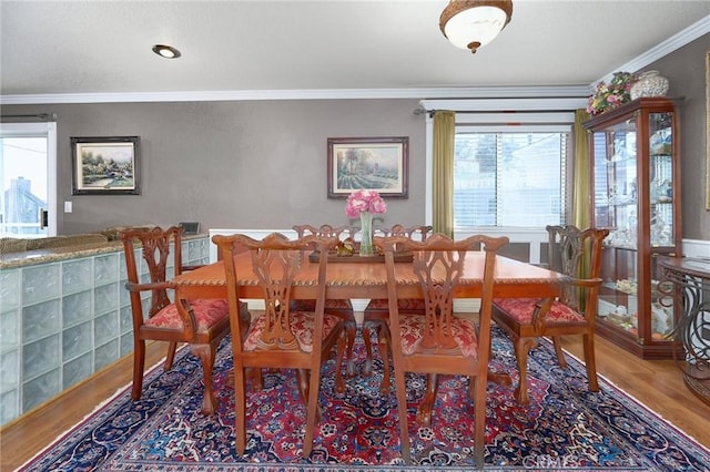 dining space featuring ornamental molding and hardwood / wood-style flooring