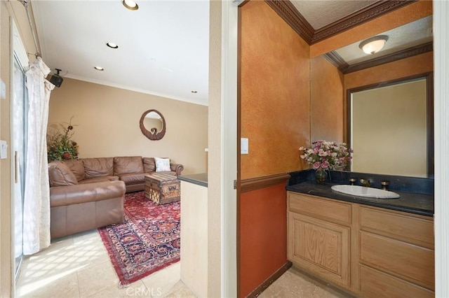 bathroom featuring tile patterned flooring, vanity, and crown molding