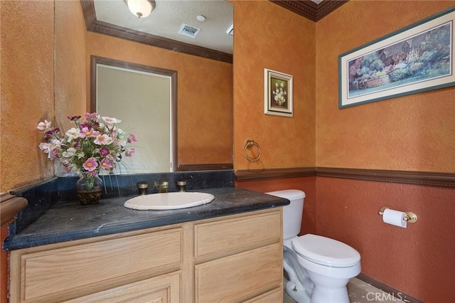 bathroom with vanity, toilet, and crown molding