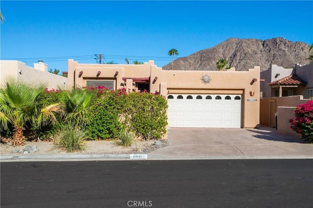 pueblo revival-style home featuring a mountain view and a garage