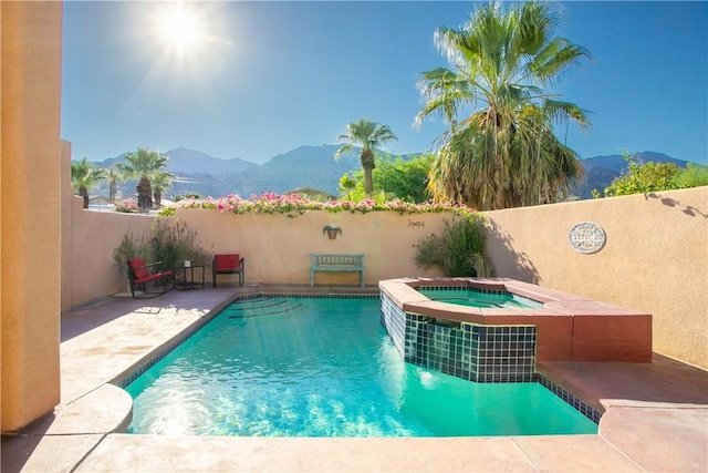 view of pool featuring a mountain view, an in ground hot tub, and a patio