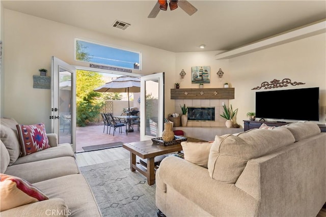 living room featuring ceiling fan, a fireplace, and light hardwood / wood-style flooring