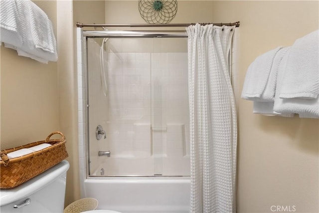 bathroom with shower / bathtub combination with curtain and toilet