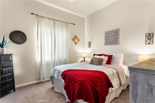 bedroom with carpet floors and lofted ceiling