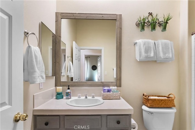 bathroom featuring vanity and toilet