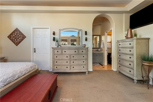 bedroom with light carpet and connected bathroom