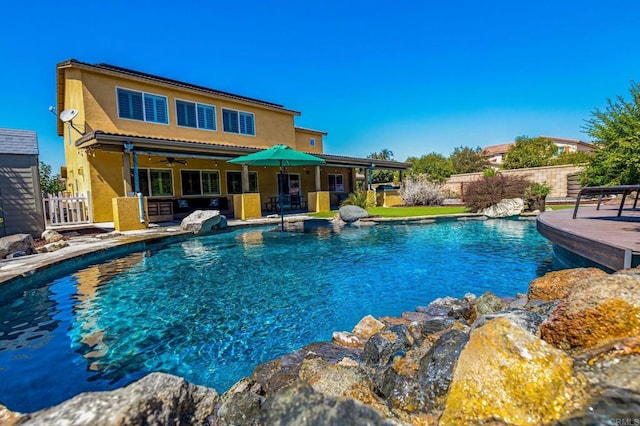 view of swimming pool featuring ceiling fan and a patio