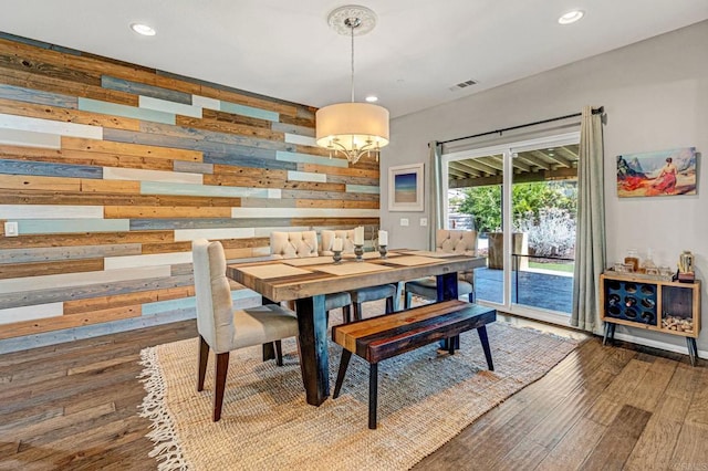 dining area with wooden walls and hardwood / wood-style flooring