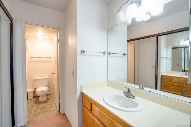 bathroom with tile patterned flooring, vanity, and toilet