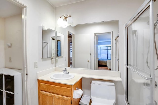 bathroom with toilet, vanity, and walk in shower