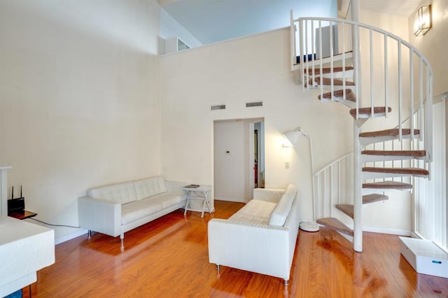 living room featuring hardwood / wood-style floors and high vaulted ceiling