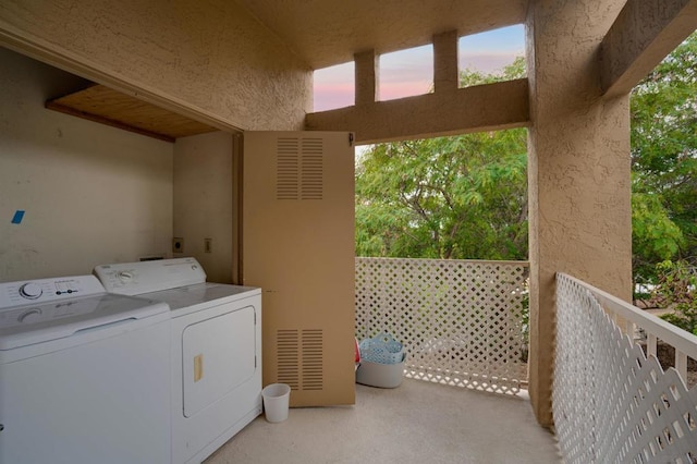 clothes washing area with separate washer and dryer and light carpet