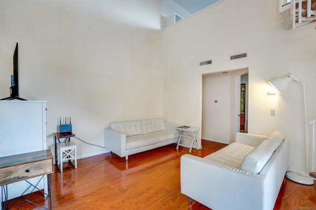 living room with a high ceiling and hardwood / wood-style flooring