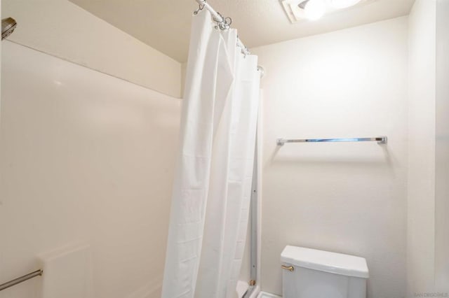 bathroom with walk in shower and toilet