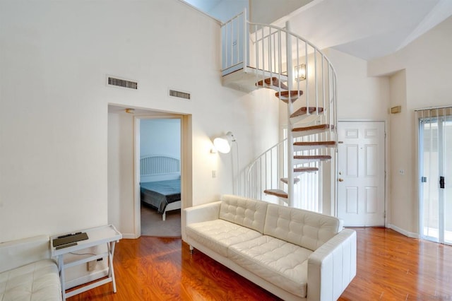 living room with a high ceiling and wood-type flooring