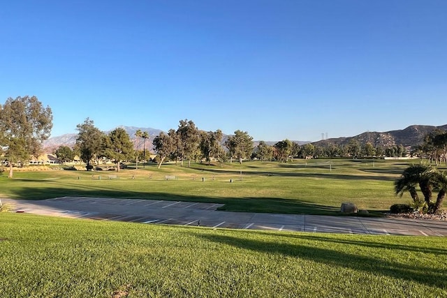 surrounding community with a mountain view and a lawn