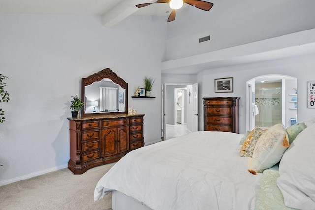 carpeted bedroom featuring ceiling fan, lofted ceiling with beams, and ensuite bath