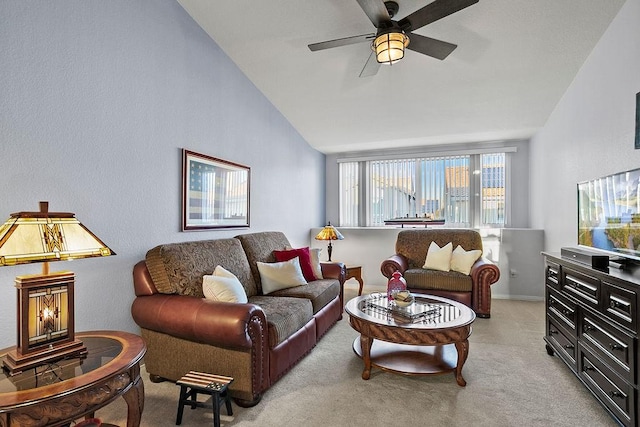 carpeted living room with ceiling fan and vaulted ceiling