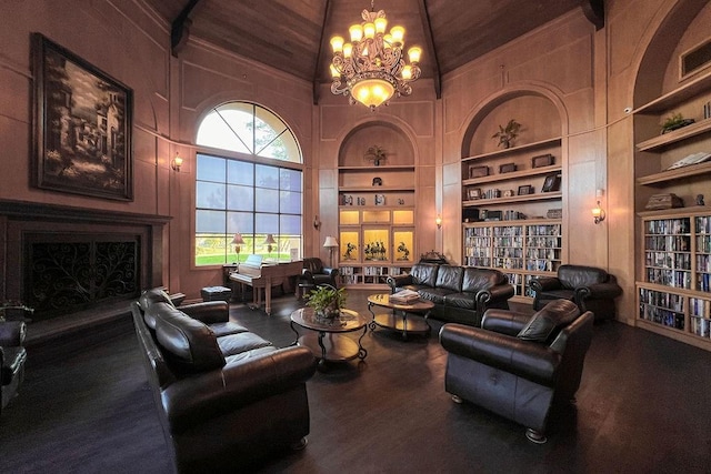 living room featuring built in features, high vaulted ceiling, hardwood / wood-style floors, and an inviting chandelier