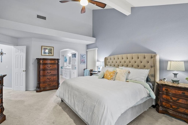 carpeted bedroom featuring vaulted ceiling with beams, ceiling fan, and connected bathroom