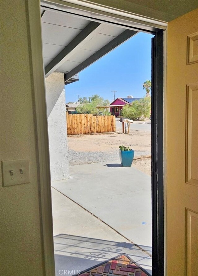 doorway featuring lofted ceiling with beams