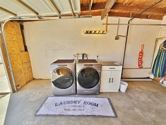 washroom with washing machine and clothes dryer and cabinets