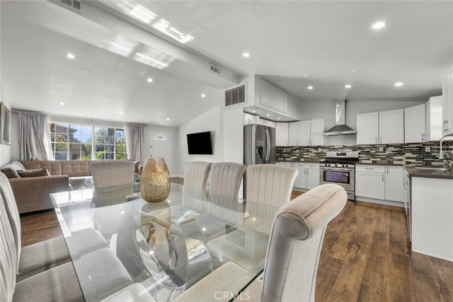 dining room featuring dark hardwood / wood-style flooring, vaulted ceiling, and sink