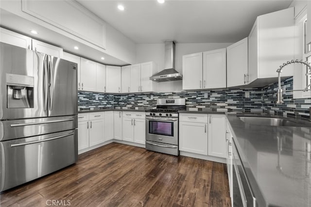 kitchen featuring white cabinets, appliances with stainless steel finishes, dark hardwood / wood-style floors, and wall chimney range hood