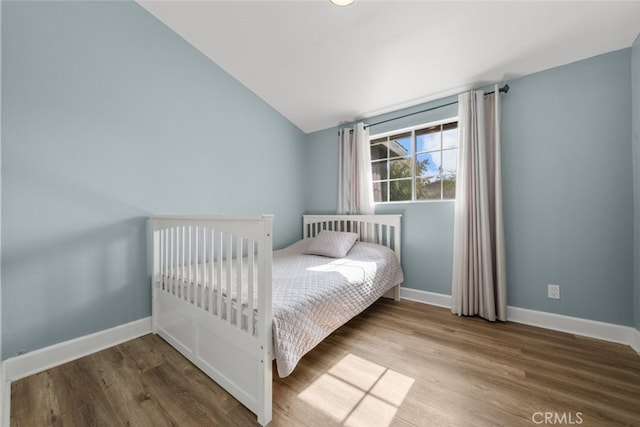 bedroom featuring lofted ceiling and hardwood / wood-style flooring