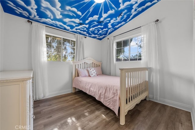 bedroom featuring multiple windows, hardwood / wood-style floors, and lofted ceiling