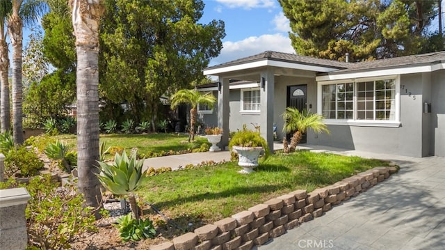 doorway to property with a lawn