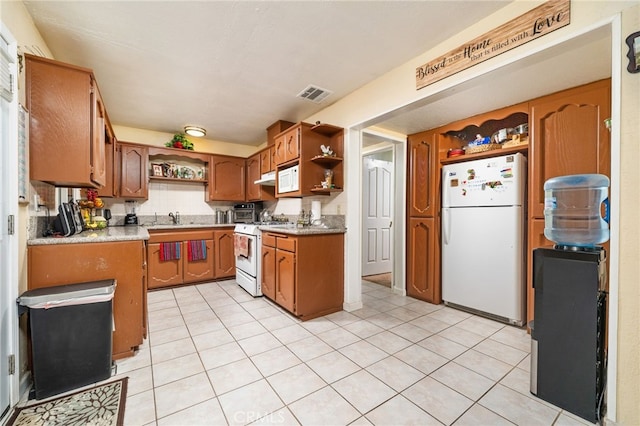 kitchen featuring decorative backsplash, white appliances, light tile patterned flooring, and sink