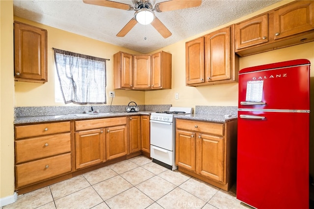 kitchen with ceiling fan, white stove, light tile patterned floors, and stainless steel fridge