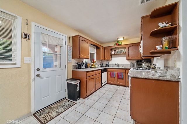 kitchen featuring light tile patterned flooring, plenty of natural light, sink, and white appliances