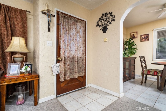 entryway with ceiling fan and light tile patterned flooring