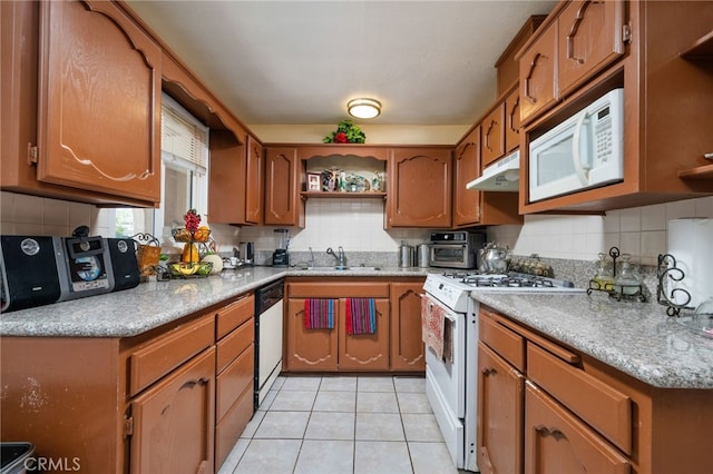 kitchen with white appliances, sink, light tile patterned floors, and tasteful backsplash