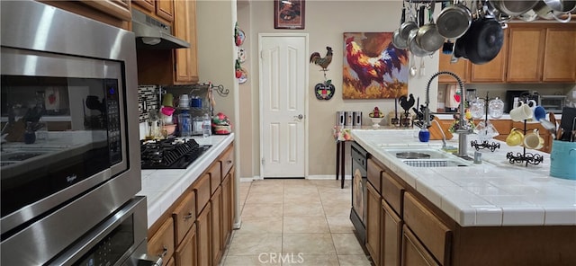 kitchen with black appliances, tile counters, light tile patterned floors, and sink