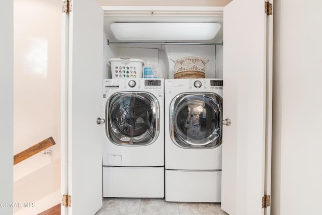 laundry room with washer and dryer and light tile patterned floors