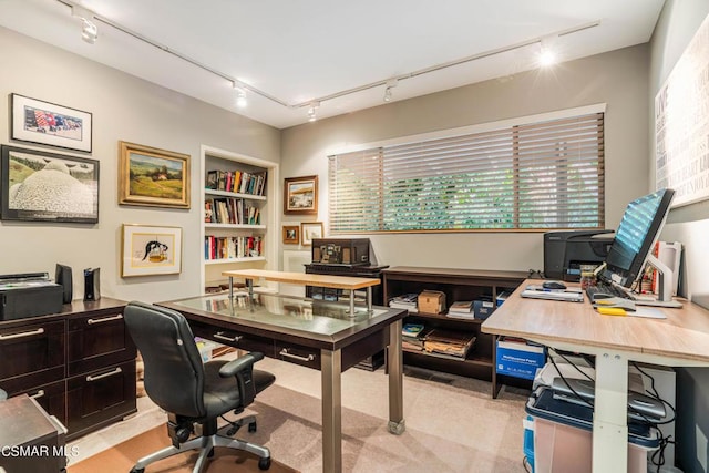 office space with built in shelves and track lighting