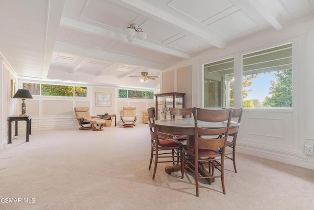 dining area featuring beamed ceiling, ceiling fan, and light carpet